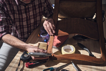 Wall Mural - Man working in a small home workshop for furniture repairing and restoration.