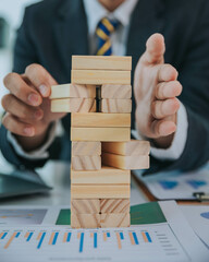 Businessman prevent falling wooden blocks planning and strategy with business risk. choice and protection investment insurance business Business risk control concept.