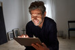 © Westend61 - Portrait of smiling mature man having fun with digital tablet at home
