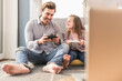 © Westend61 - Young man and little girl playing computer game with gaming console