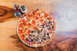 Top view of a supreme mixed pizza on wooden table. High angle view of mixed supreme pizza on wooden table
