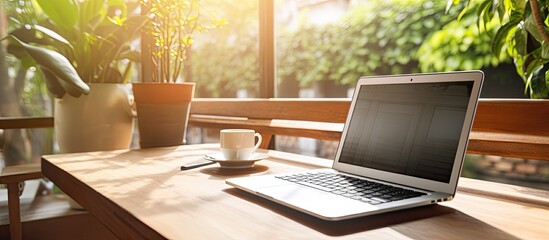 Poster - The Home Office Concept portrays a designated area for working from home, situated near a window. It features a modern laptop with a blurred screen and a glass cup of tea on the table. is a close-up