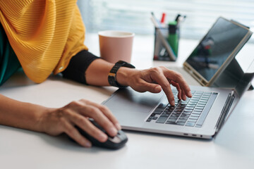 Wall Mural - Hands of muslim businesswoman working on laptop at office desk