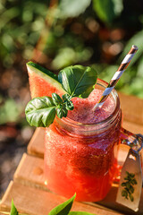 Wall Mural - watermelon smoothie on a wooden table outside