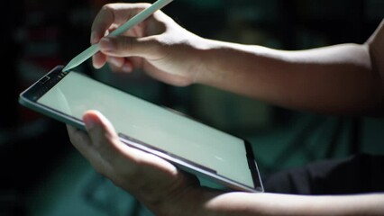 Professional artists use technology to create art by stylus and application on tablet, close-up shot