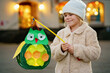 © Irina Schmidt - Little preschool kid girl holding selfmade traditional owl lanterns with candle for St. Martin procession. child happy about children and family parade in kindergarten. German tradition Martinsumzug