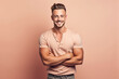 © Brastock Images / AI - Handsome blond man with a goatee smiling with arms crossed on a pink background. Generative AI.