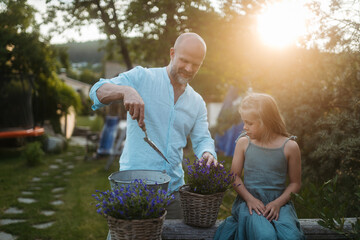 Wall Mural - Father and daughter taking care of plants in the garden.