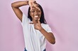 African young woman wearing casual white t shirt smiling making frame with hands and fingers with happy face. creativity and photography concept.