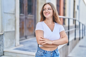 Sticker - Young blonde woman standing with arms crossed gesture at street