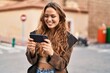 © Krakenimages.com - Young beautiful hispanic woman smiling confident watching video on smartphone at street