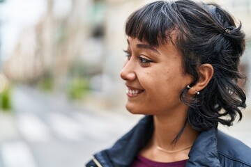 Wall Mural - Young beautiful hispanic woman smiling confident looking to the side at street