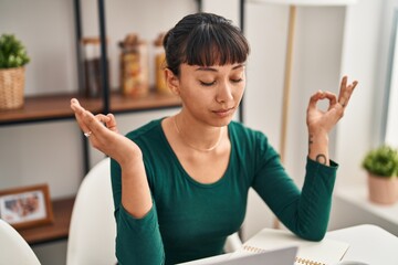 Sticker - Young beautiful hispanic woman sitting on table doing yoga exercise at home