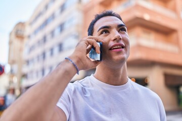 Sticker - Young hispanic man smiling confident talking on the smartphone at street