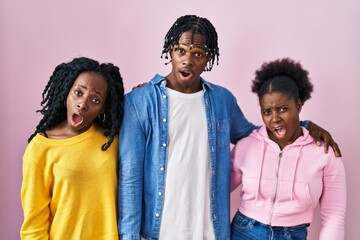 Sticker - Group of three young black people standing together over pink background in shock face, looking skeptical and sarcastic, surprised with open mouth