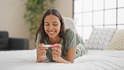 Canvas Print - African american woman smiling confident holding pregnancy test at bedroom