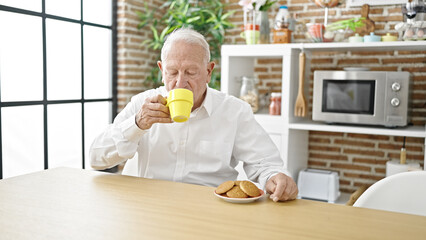 Canvas Print - Senior grey-haired man having breakfast sitting on table at dinning room