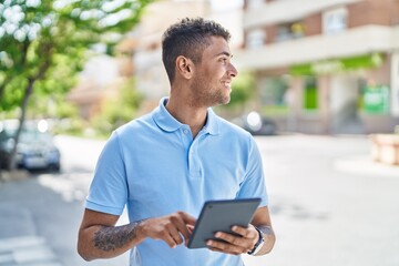 Canvas Print - African american man smiling confident using touchpad at street