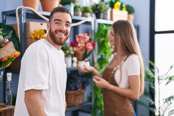 Man and woman customer asking to florist for plant pot at flower shop