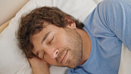 Wall Mural - Young hispanic man lying on bed sleeping at bedroom