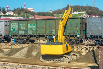 Wall Mural - Unloading unloading rubble with an excavator railway carriage wagons with bulk cargo gravel, sand at the station.