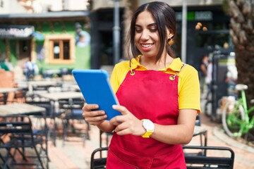 Poster - Young beautiful arab woman waitress smiling confident using touchpad at coffee shop terrace