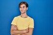 © Krakenimages.com - Young man standing over blue background smiling looking to the side and staring away thinking.