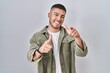 © Krakenimages.com - Young hispanic man standing over isolated background pointing fingers to camera with happy and funny face. good energy and vibes.