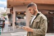 © Krakenimages.com - Young hispanic man using smartphone at street