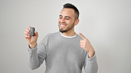 Poster - Hispanic man smiling confident pointing to key of new car over isolated white background