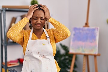 Wall Mural - African american woman with braids at art studio suffering from headache desperate and stressed because pain and migraine. hands on head.