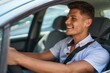 © Krakenimages.com - Young hispanic man smiling confident driving car at street