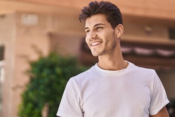 Sticker - Young hispanic man smiling confident looking to the side at park