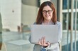 © Krakenimages.com - Young woman business worker smiling confident using laptop at street