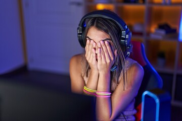 Poster - Young beautiful hispanic woman streamer stressed using computer at gaming room