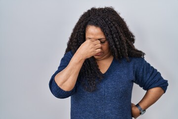 Sticker - Plus size hispanic woman standing over white background tired rubbing nose and eyes feeling fatigue and headache. stress and frustration concept.