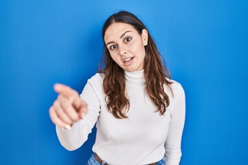 Sticker - Young hispanic woman standing over blue background pointing displeased and frustrated to the camera, angry and furious with you