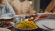 Close-up dish of halal food biryani rice on plate. Asia muslim sweet daughter serve food to mother Ramadan dinner together at home. Family celebration end of Eid al-Fitr togetherness at home.
