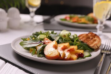 Delicious salad with peach slices served on table, closeup