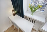 Fototapeta  - Jasna sypialnia z zielonym łózkiem i białym biurkiem do pracy