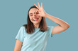 © Pixel-Shot - Young woman showing OK on blue background
