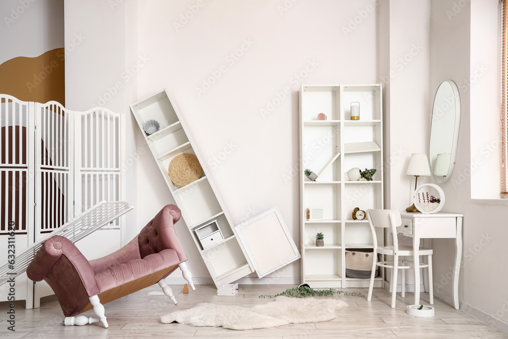 Armchair with folding screen and dressing table in messy room