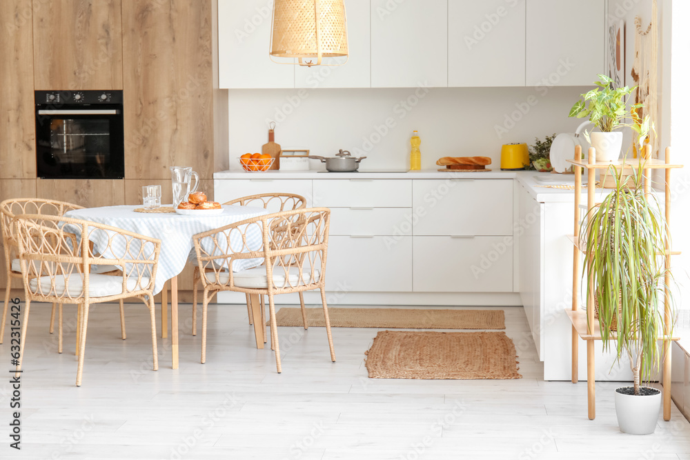 Interior of modern kitchen with dining table and white counters