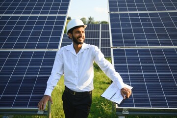 Portrait young indian technician or manager wearing formal cloths standing with solar panel. renewable energy, man standing crossed arm, copy space