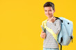 © Pixel-Shot - Portrait of happy schoolboy with backpack on orange background