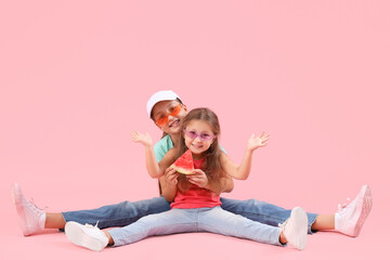 Canvas Print - Happy little girls with slice of fresh watermelon sitting on pink background