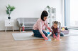 © sofiko14 - Young caucasian lady and cute kid in rubber gloves polishing floor with cloths after vacuuming carpet in living room. Loving parent showing tween girl family techniques for cleaning various surfaces.