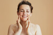 © Alliance - smiling modern 40 years old woman with face scrub