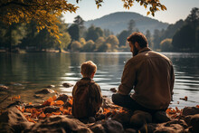 Dad And Son Enjoy A Peaceful Day Of Fishing Together At The Lake During Their Autumn Family Trip, Creating Cherished Memories And Strengthening Their Bond At Sunrise