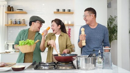 Wall Mural - Group of Diversity Asian people enjoy and fun dancing during cooking together in the kitchen at home. Man, woman and lgbtq person having celebration dinner party meeting together on holiday vacation.